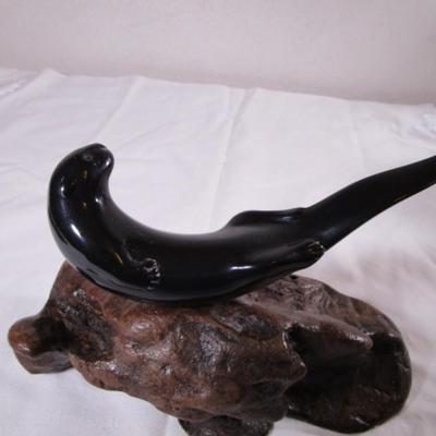 Vintage John Perry signed black otter figurine on a beryl wood stand