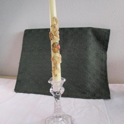 Clear glass candlestick holder with decorative candle