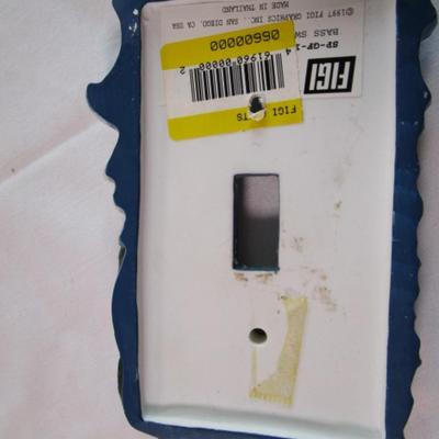 Light switch covers, one is mirrored, one has a fish