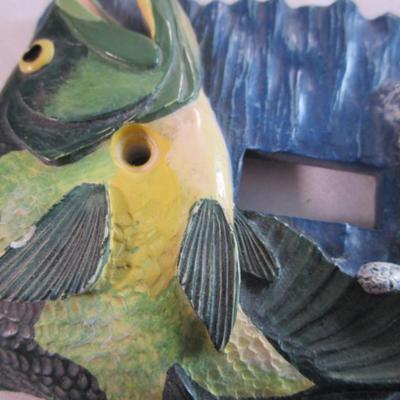 Light switch covers, one is mirrored, one has a fish