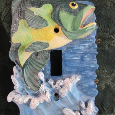 Light switch covers, one is mirrored, one has a fish
