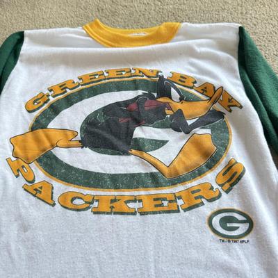 LOT 216A: NFL Team Merch: Green Bay Packers (Shirts, Jersey, Sweatpants), Miami Dolphins (Bedazzled Tee, Dan Marino Starter T, Jersey),...