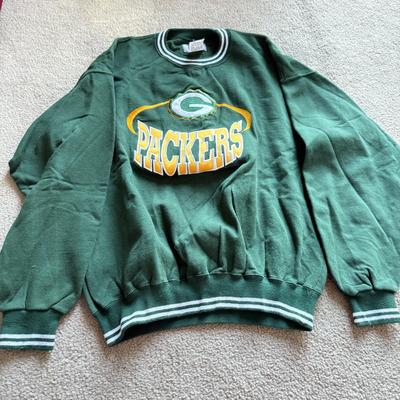 LOT 216A: NFL Team Merch: Green Bay Packers (Shirts, Jersey, Sweatpants), Miami Dolphins (Bedazzled Tee, Dan Marino Starter T, Jersey),...