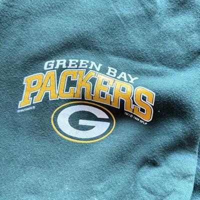 LOT 216A: NFL Team Merch: Green Bay Packers (Shirts, Jersey, Sweatpants), Miami Dolphins (Bedazzled Tee, Dan Marino Starter T, Jersey),...