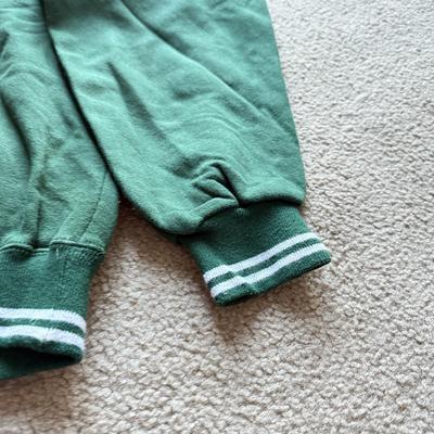 LOT 216A: NFL Team Merch: Green Bay Packers (Shirts, Jersey, Sweatpants), Miami Dolphins (Bedazzled Tee, Dan Marino Starter T, Jersey),...