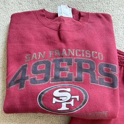 LOT 216A: NFL Team Merch: Green Bay Packers (Shirts, Jersey, Sweatpants), Miami Dolphins (Bedazzled Tee, Dan Marino Starter T, Jersey),...