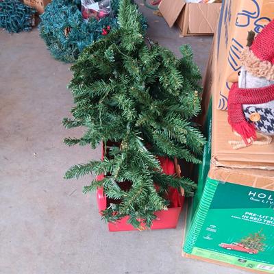 PRE-LIT TREE ON TOP OF RED TRUCK, WREATHS, FAUX FLOWERS AND SMALL PLUSH ANIMALS