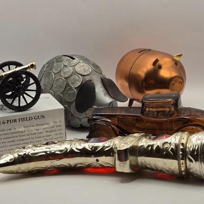 LOT 114K: Two Piggy Banks, Avon Cologne Decanters, & Small Replica of English Field Gun