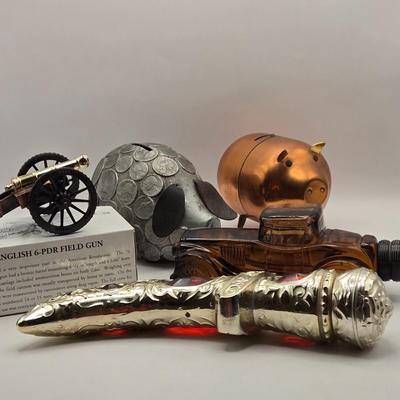 LOT 114K: Two Piggy Banks, Avon Cologne Decanters, & Small Replica of English Field Gun