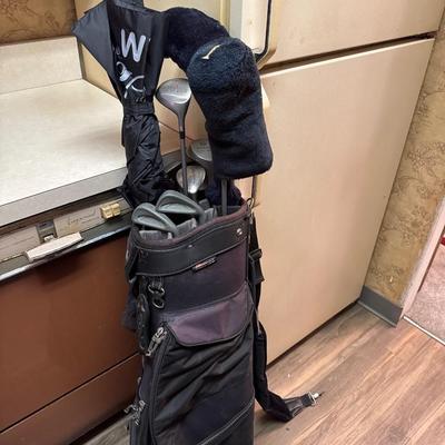 Golf clubs, bag and umbrella