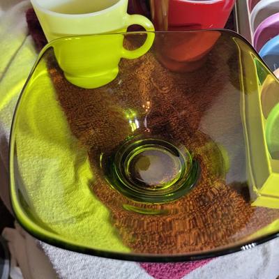 Coasters, colorful coffee cups and green crystal candy dish