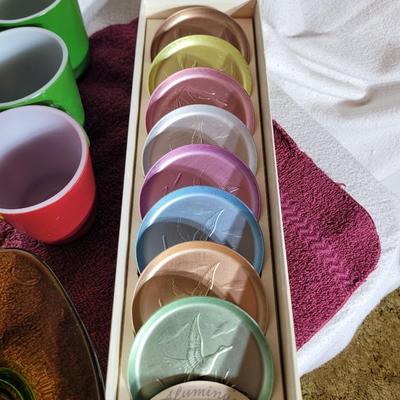 Coasters, colorful coffee cups and green crystal candy dish