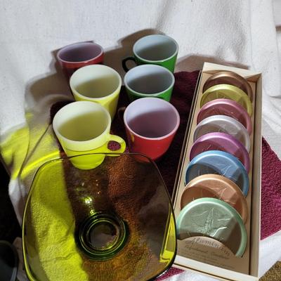 Coasters, colorful coffee cups and green crystal candy dish