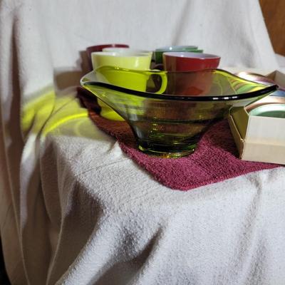 Coasters, colorful coffee cups and green crystal candy dish