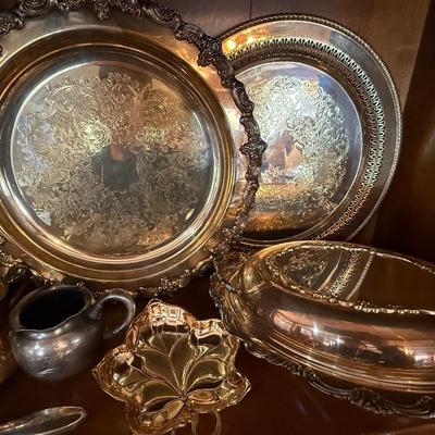 Shelf full of silver-plate pieces - platters, cups, etc.,