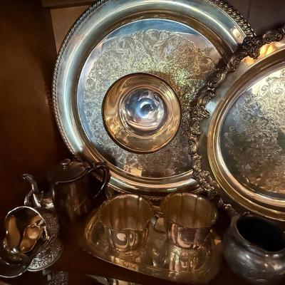Shelf full of silver-plate pieces - platters, cups, etc.,