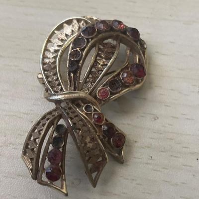 Gold toned ribbon pin