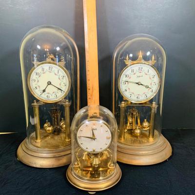 LOT 31: Set of Three (3) Mechanical Glass Dome Anniversary Clocks Featuring John Wanamaker, Forestville German Made Clock and a Smaller...