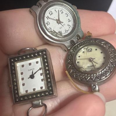 Silver toned watch band and random watch faces