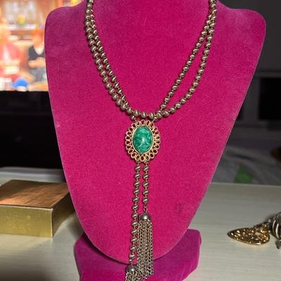 Long golden toned chain with green bead