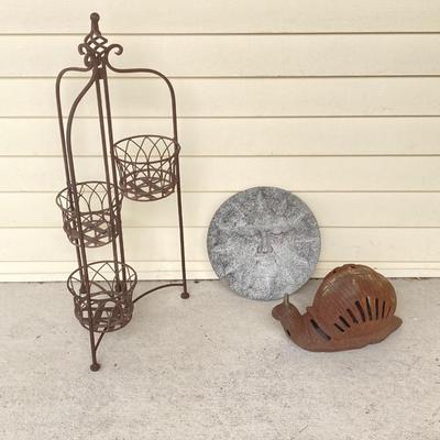 LOT 124G: Cast Iron Snail, Three Tier Folding Plant Stand and Concrete Sun Face Plaque