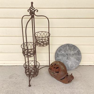 LOT 124G: Cast Iron Snail, Three Tier Folding Plant Stand and Concrete Sun Face Plaque