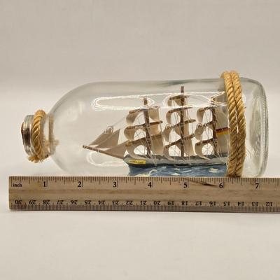 LOT 100B: Lighthouse Plate/Light, Two Ships in Bottles, and Vintage Jennings Bros. Silver Tone Sailboat Paperweight