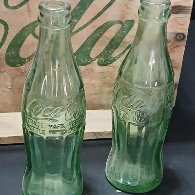 Vintage 1976 wooden Coca Cola crate with coca cola bottles, antique opener and a collectable book