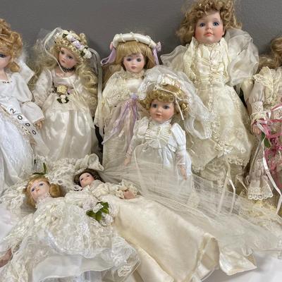 8 porcelain dolls dressed in cream