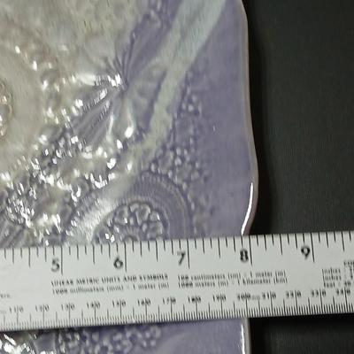 Two purple pottery dishes with signatures on the backs
