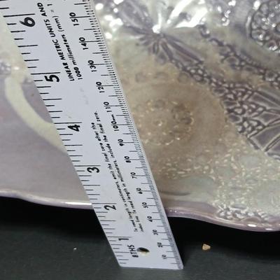 Two purple pottery dishes with signatures on the backs