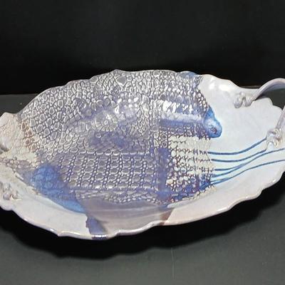 Two purple pottery dishes with signatures on the backs