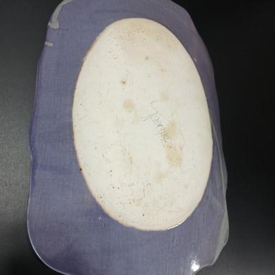 Two purple pottery dishes with signatures on the backs