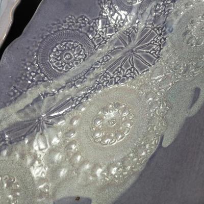 Two purple pottery dishes with signatures on the backs