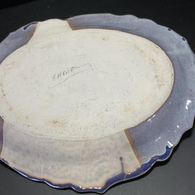Two purple pottery dishes with signatures on the backs