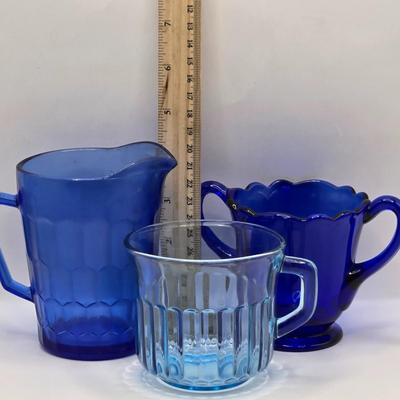 LOT 212D: Multiple Pieces of Colorful Glass Including Amber Plates, Amber Cups Made in France, 3 Pieces of Blue Glass, Candy Dish with...