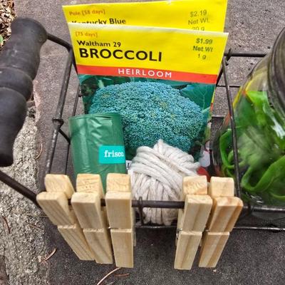 Gardening items - Vegetable seeds in a wire basket - Knee pad - Jars with gardening items - Garden knife - Hand rake and more