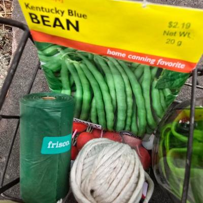 Gardening items - Vegetable seeds in a wire basket - Knee pad - Jars with gardening items - Garden knife - Hand rake and more