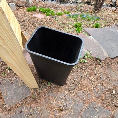 Wooden sawhorse, a blue tarp, Irwin clamp, and a trashcan