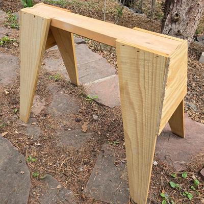 Wooden sawhorse, a blue tarp, Irwin clamp, and a trashcan