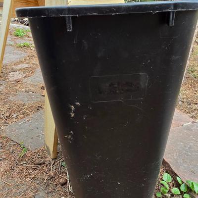 Wooden sawhorse, a blue tarp, Irwin clamp, and a trashcan
