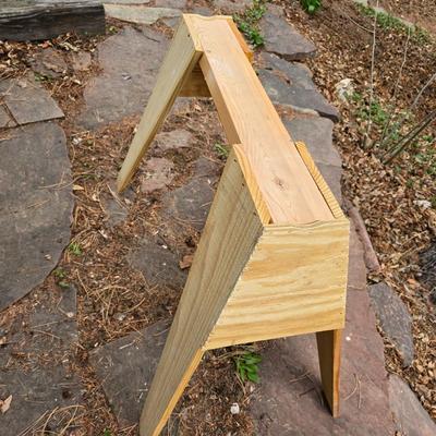 Wooden sawhorse, a blue tarp, Irwin clamp, and a trashcan