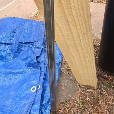 Wooden sawhorse, a blue tarp, Irwin clamp, and a trashcan