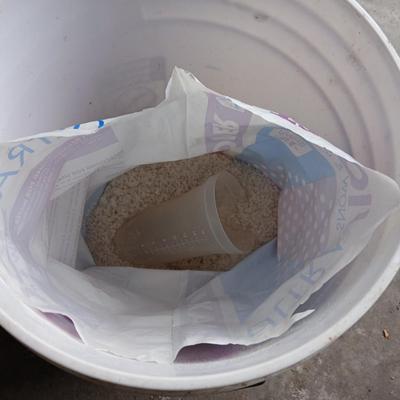 Two snow shovels - one metal - one plastic and a lidded bucket for ice melt