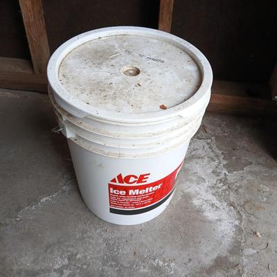 Two snow shovels - one metal - one plastic and a lidded bucket for ice melt