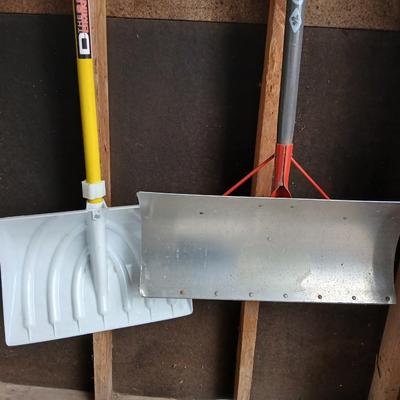Two snow shovels - one metal - one plastic and a lidded bucket for ice melt