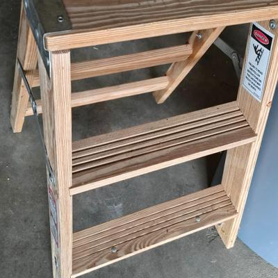 Wood 2 foot step ladder and a grey plastic trashcan