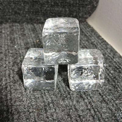Empty Glass Frosted bottle with horse rear stopper and three glass ice cubes / clear glass cubes