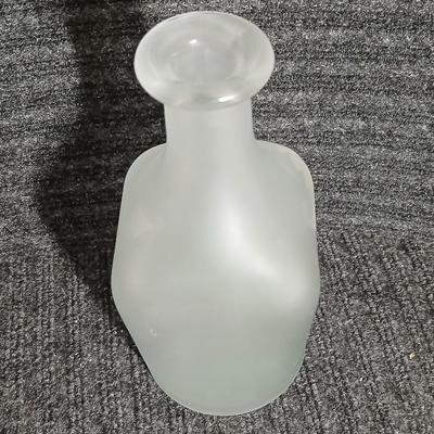 Empty Glass Frosted bottle with horse rear stopper and three glass ice cubes / clear glass cubes
