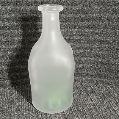 Empty Glass Frosted bottle with horse rear stopper and three glass ice cubes / clear glass cubes